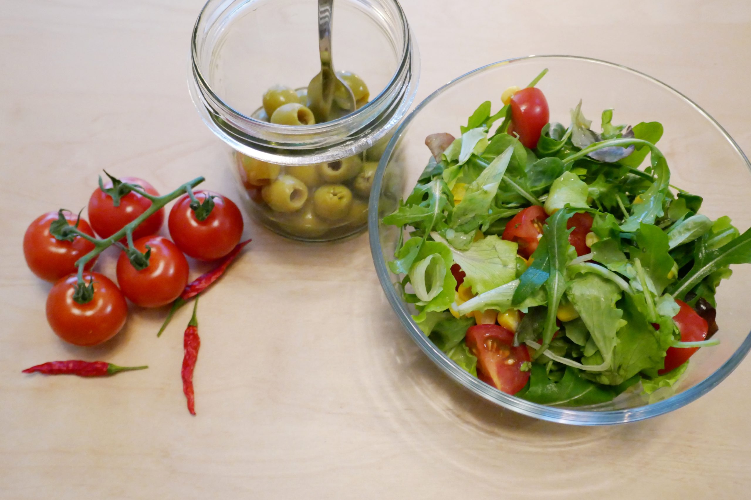 Cocktailtomaten, grüne Oliven, Salat und Chilis