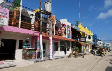 Unbefestigte, autofreie Straßen mit bunten Häusern auf der Isla Holbox in Mexiko