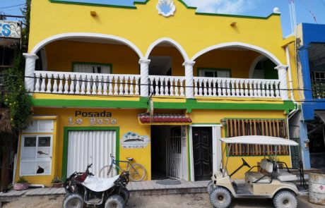 Gelbes Haus mit Golfcart und Quad auf der Isla Holbox in Mexiko