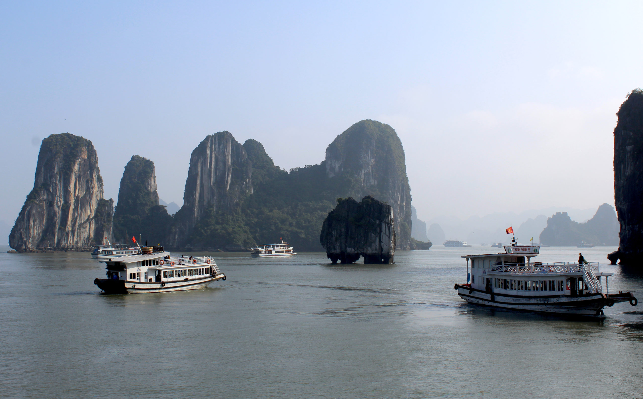 Schiffe vor einer Kalksteininsel in der Ha-Long-Bay in Vietnam