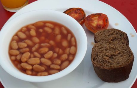 Veganes Frühstück, Baked Beans, Brot und gegrillte Tomaten in Bangkok, Thailand