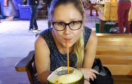 Frau trinkt frische Kokosnuss am Nachtmarkt in Chiang Mai Thailand