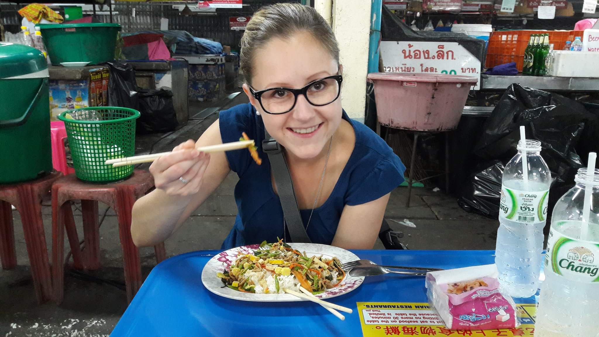 Woman enjoying Streetfood in Chiang Mai, Thailand on a table